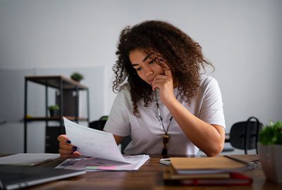 Mujer revisando notificaciones y documentos de una Sección de Desnaturalización