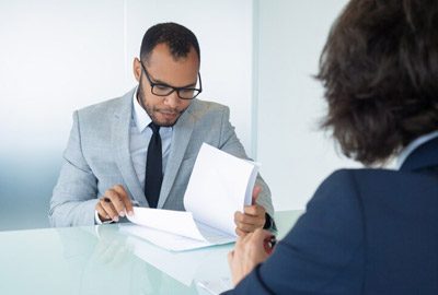 Abogado y cliente discutiendo sobre documentos necesarios para el proceso consular